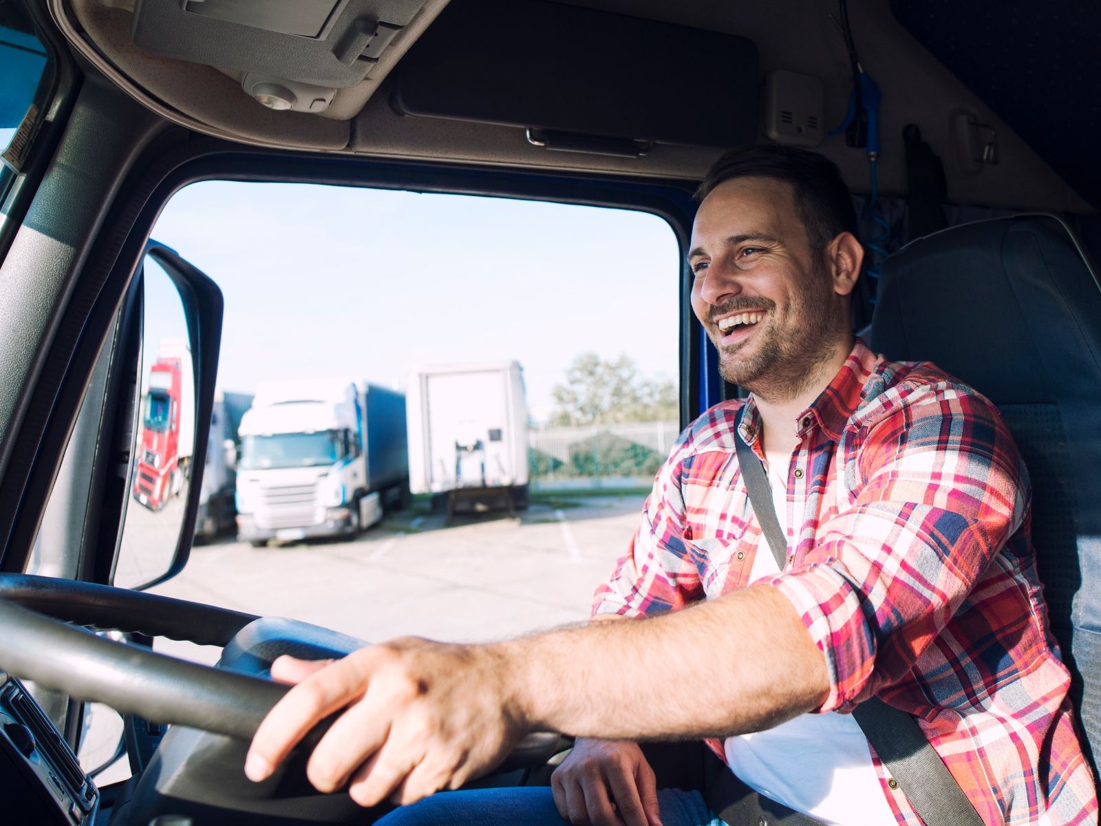 Truck driver seated inside a commercial truck cab.