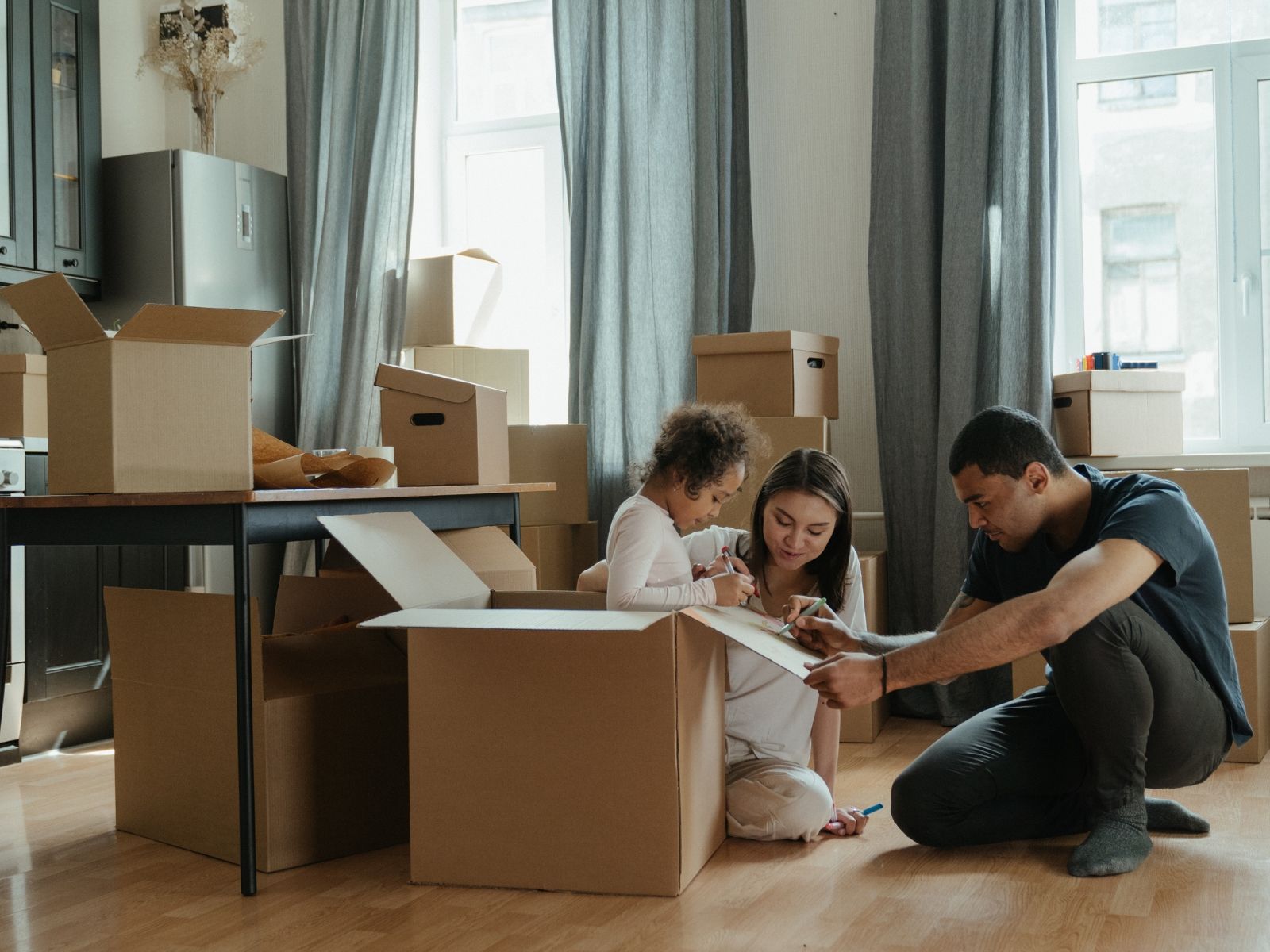A family carrying boxes into their new home