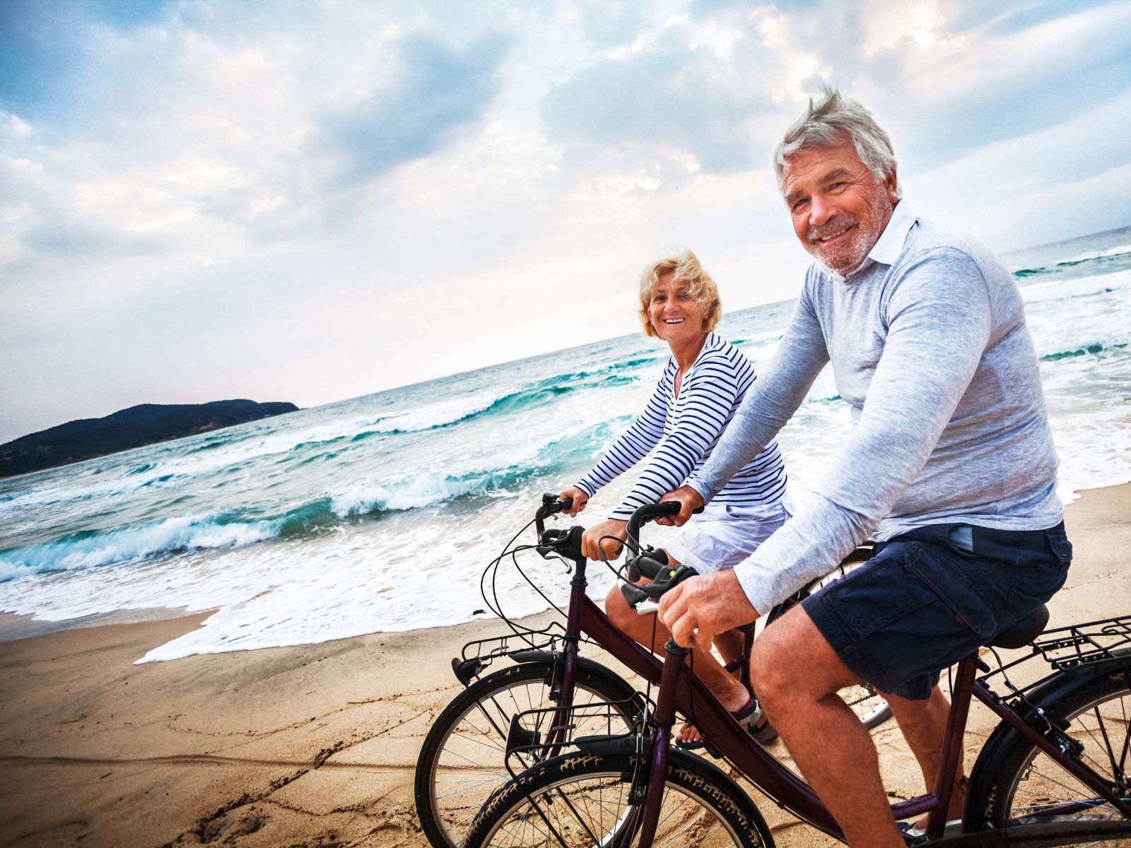 An older couple riding bicycles together